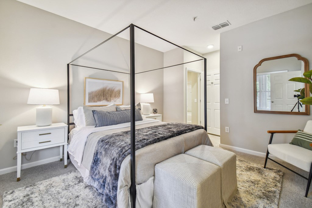 a bedroom with a canopy bed and a mirror