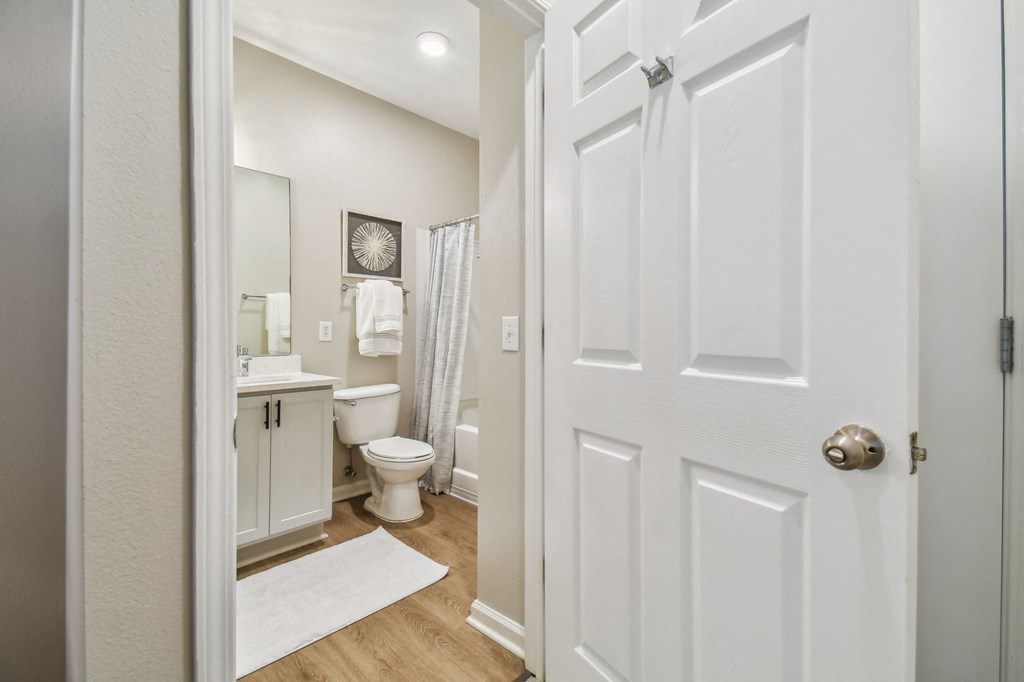 a bathroom with a white door and a toilet and a sink