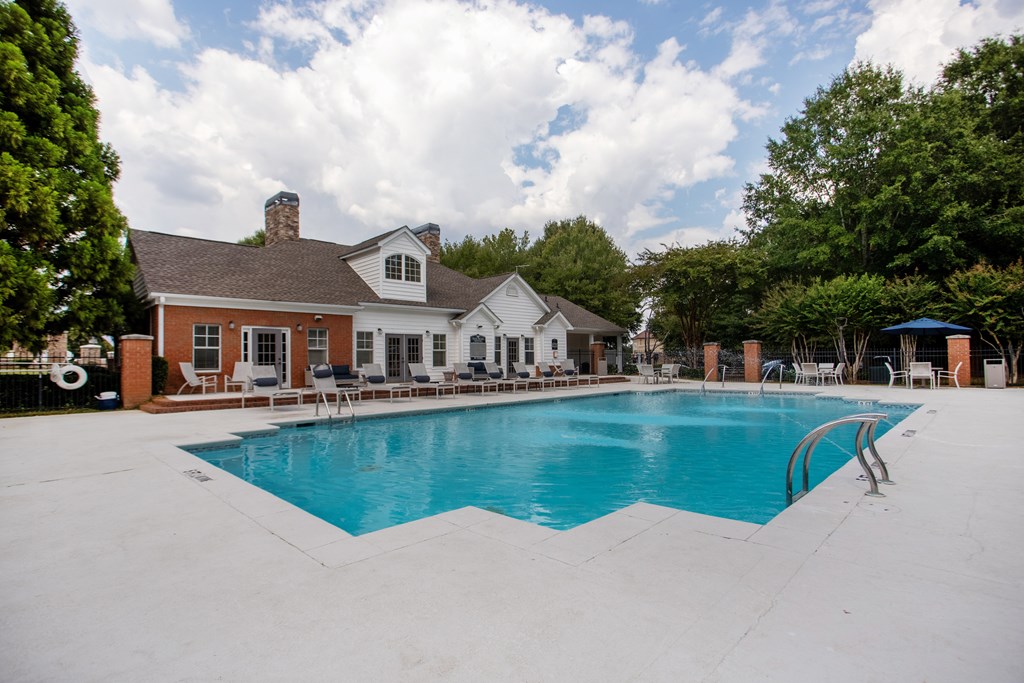 A large swimming pool in front of a house.