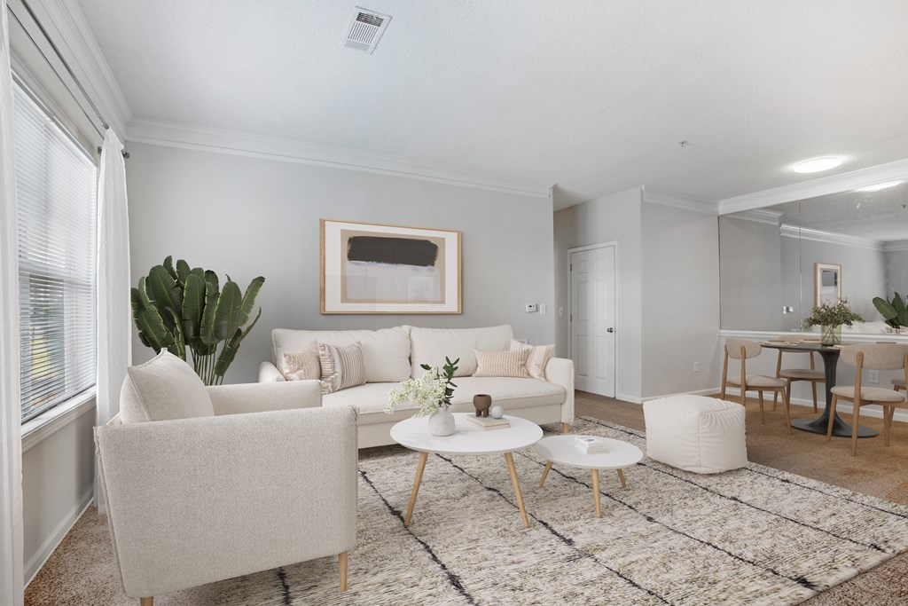 A living room with a white couch, a coffee table, and a painting on the wall.