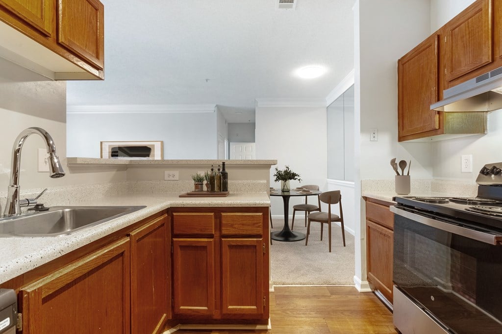 A kitchen with wooden cabinets and a stainless steel oven.