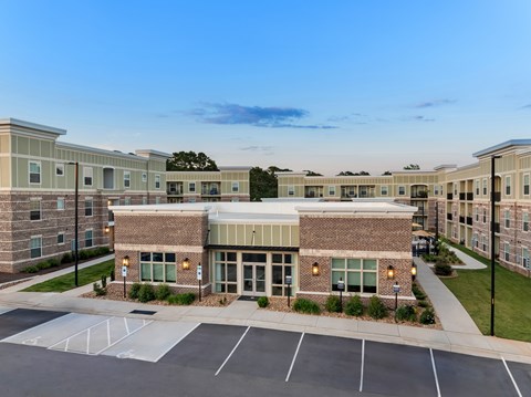A parking lot in front of a building with a clear blue sky above.
