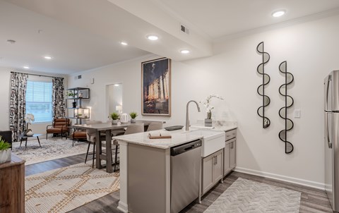 A modern kitchen with a large island and a dining area.