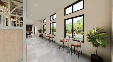 A long hallway with a table and chairs on the side.