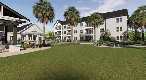 A large grassy area in front of a building with palm trees.