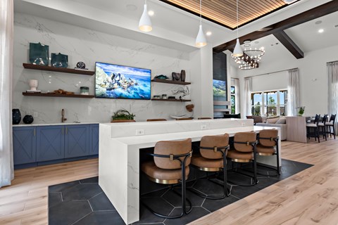 A modern kitchen with a bar area and a television mounted on the wall.