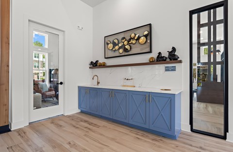A modern kitchen with blue cabinets and a wooden floor.