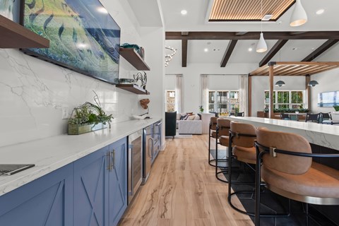 A modern kitchen with blue cabinets and wooden floors.