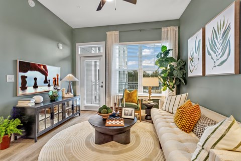 A living room with a white sofa and a coffee table in the center.
