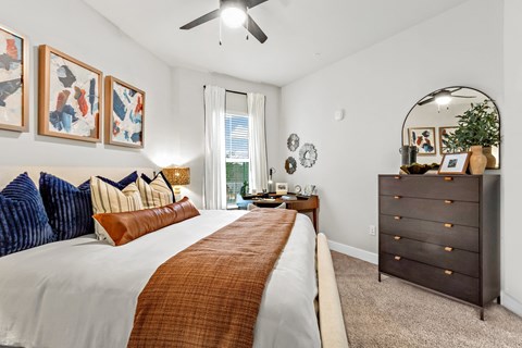 A bedroom with a large bed and a dresser.