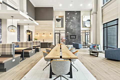 A modern dining area with a long wooden table and grey chairs.