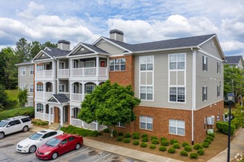 Apartment building with grey siding and red brick at The Columns at Club Drive, Duluth, GA - Photo Gallery 6