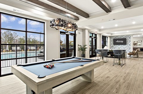 A billiard table is in the middle of a room with a pool table and a bar.