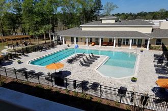 Resort style swimming pool with tanning ledge and sun deck at The Columns at Coldbrook Station, 31407