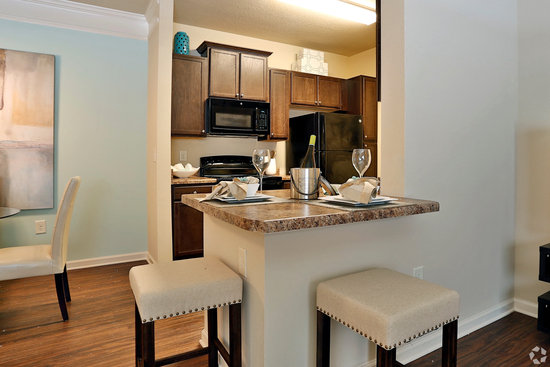 Designer kitchens with bar seating and black appliances at The Columns at Coldbrook Station, 31407