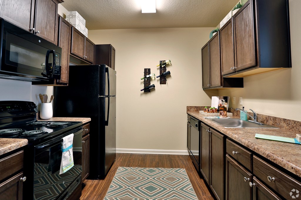 Modern kitchen with walnut cabinetry and faux wood flooring at The Columns at Coldbrook Station, Port Wentworth, Georgia