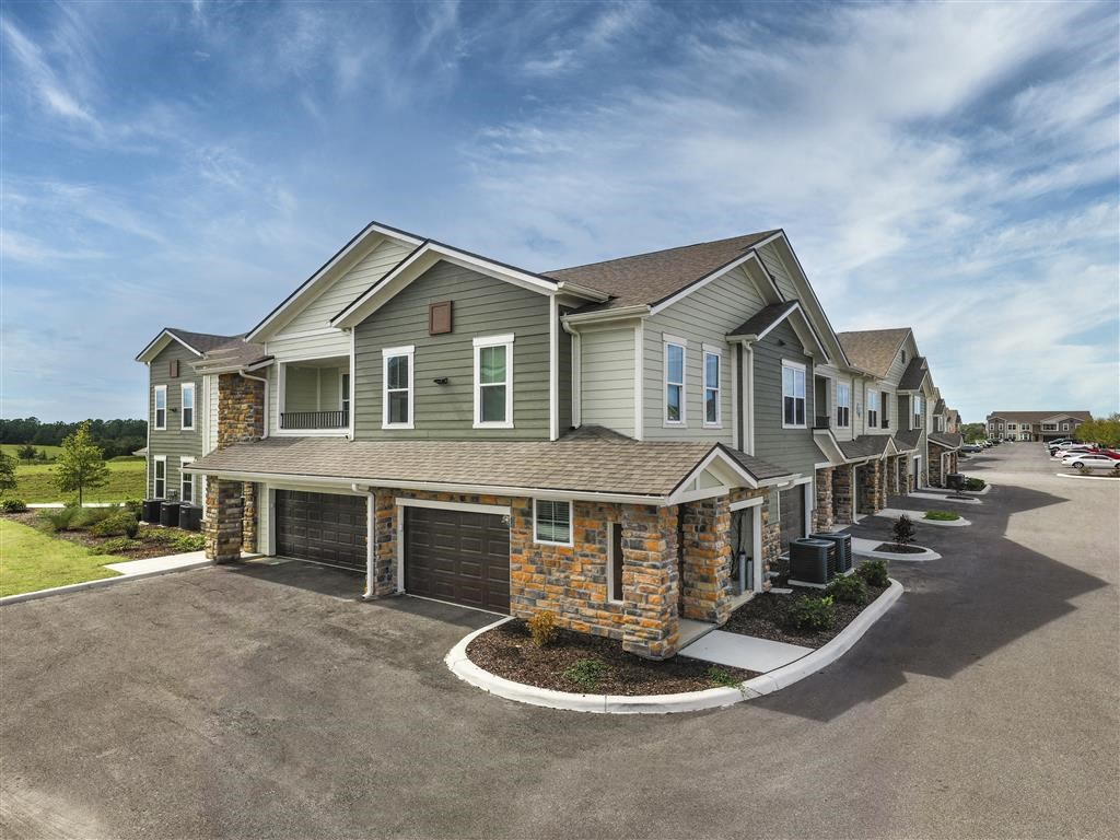 a row of houses on a street with a blue sky in the background at Verso Apartments, Davenport, 33896