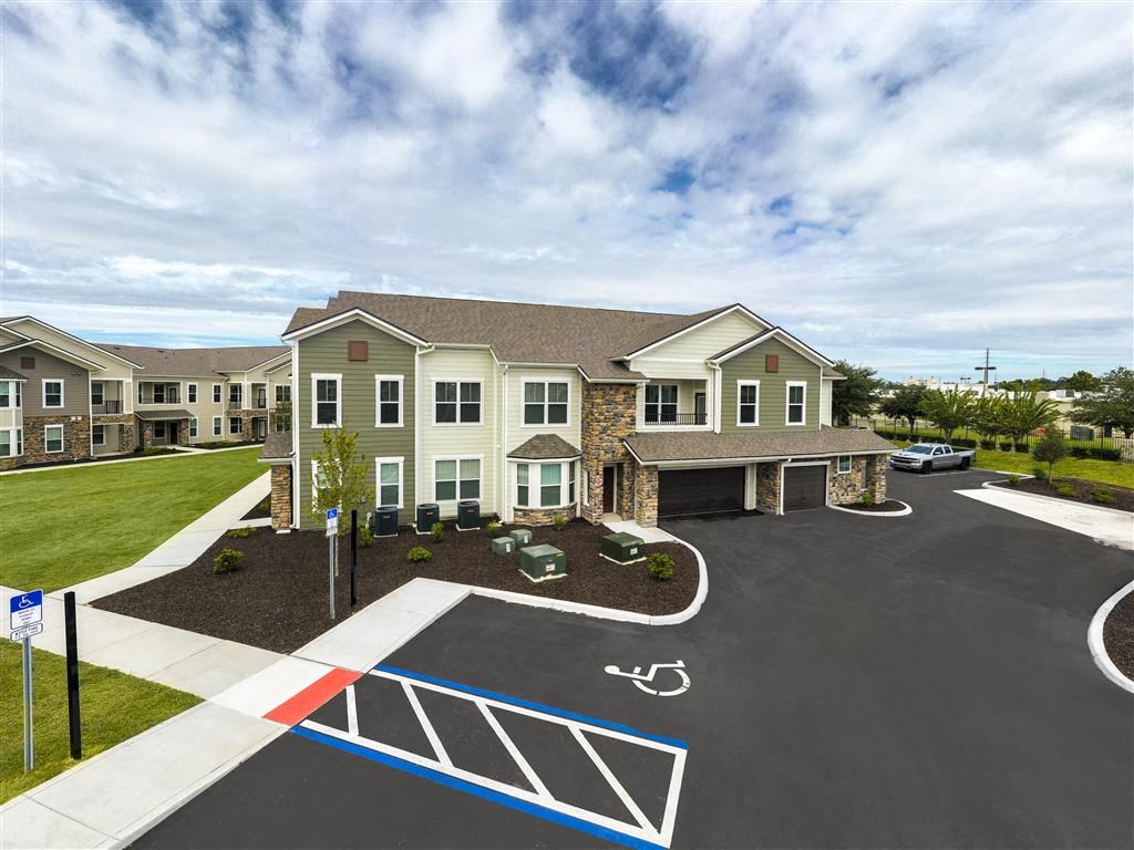 a large house with a parking lot and a handicapped parking lot at Verso Apartments, Florida, 33896