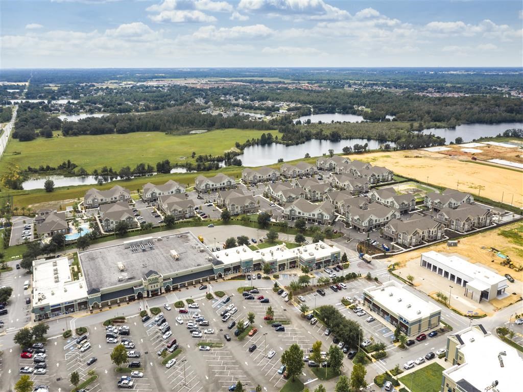 an aerial view of a large group of houses in a parking lot with a lake at Verso Apartments, Florida