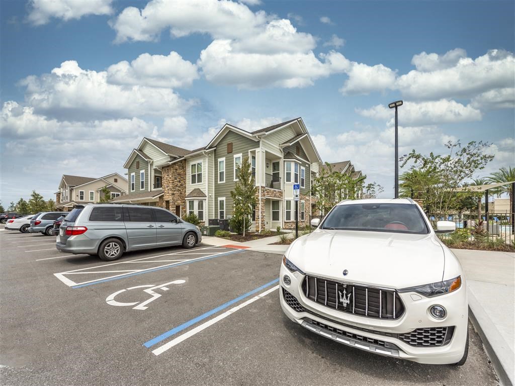 a white maserati ghibli parked in a parking lot at Verso Apartments, Davenport, FL