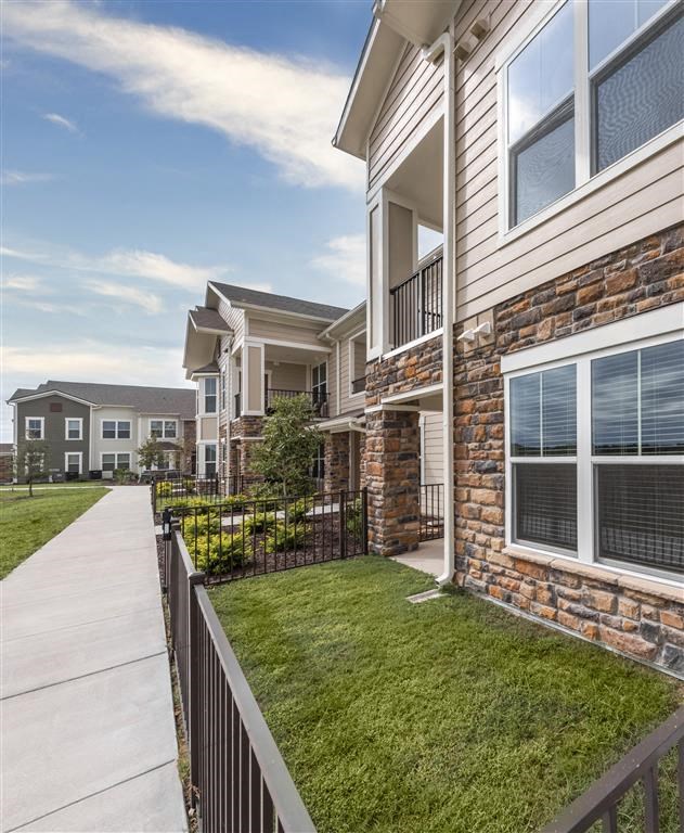 a building with a sidewalk and grassy area at Verso Apartments, Davenport, Florida
