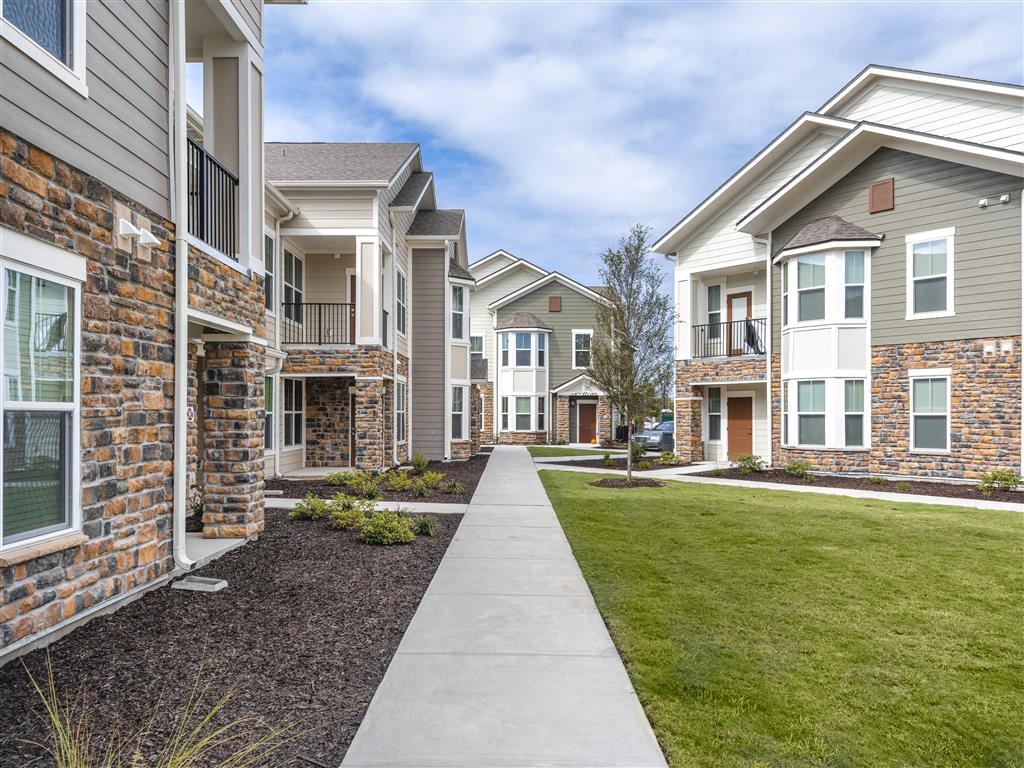 a row of townhomes with a sidewalk in front of them at Verso Apartments, Florida