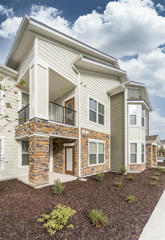 a large white house with a stone and brick facade at Verso Apartments, Davenport