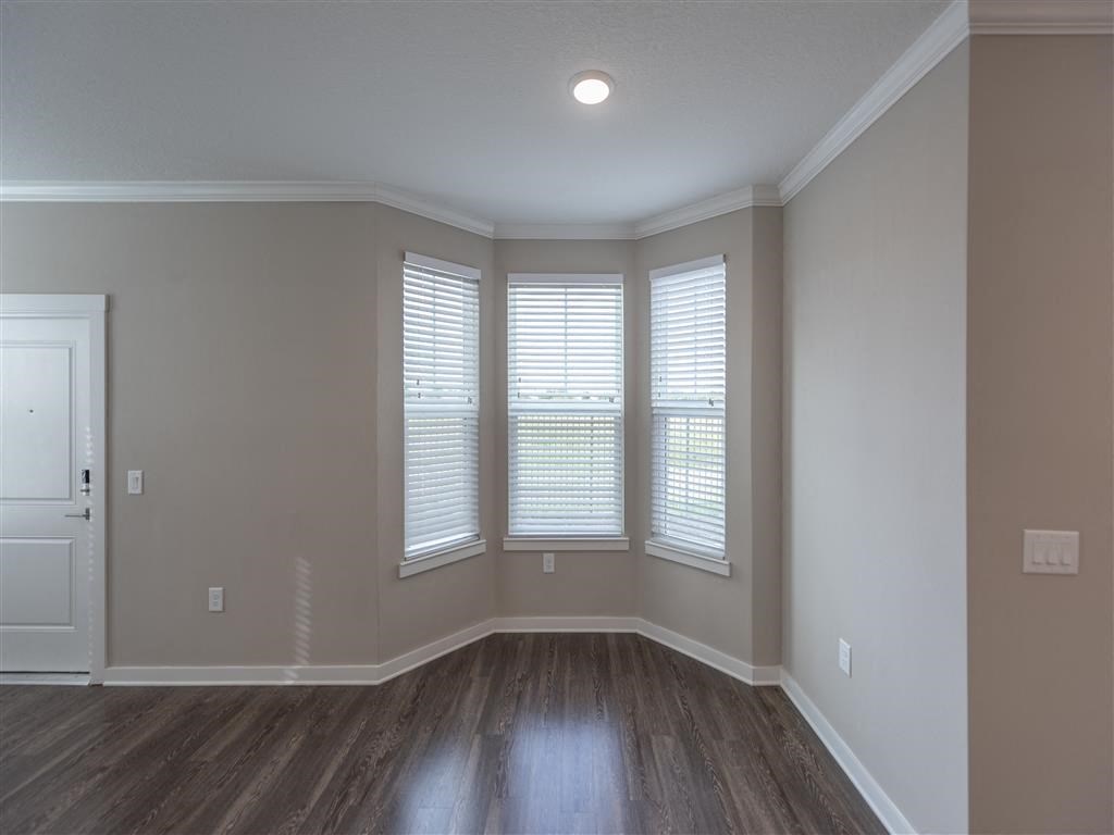 an empty room with three windows and a door at Verso Apartments, Florida