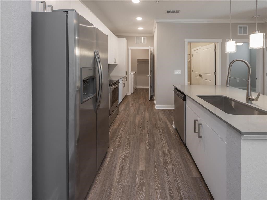 a kitchen with a stainless steel refrigerator freezer next to a sink at Verso Apartments, Davenport