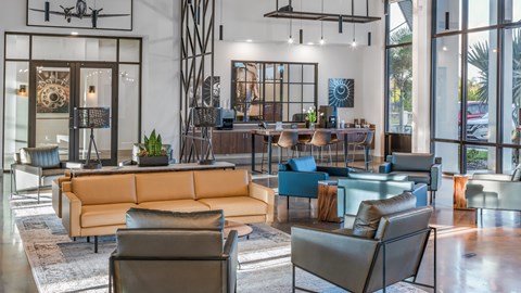 A modern living room with a large sofa and a glass table.