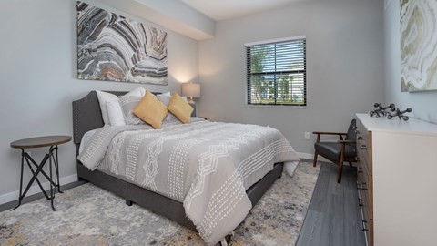 A bedroom with a large bed and a painting on the wall.
