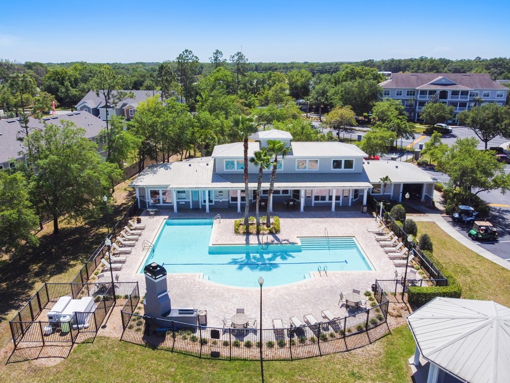 an aerial view of the resort style pool with lounge chairs and umbrellas