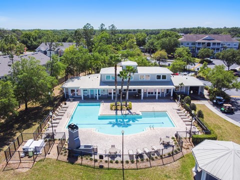 an aerial view of the resort style pool with lounge chairs and umbrellas