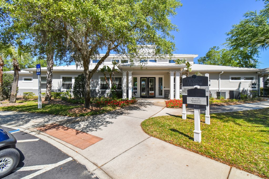 a white building with a black sign in front of it
