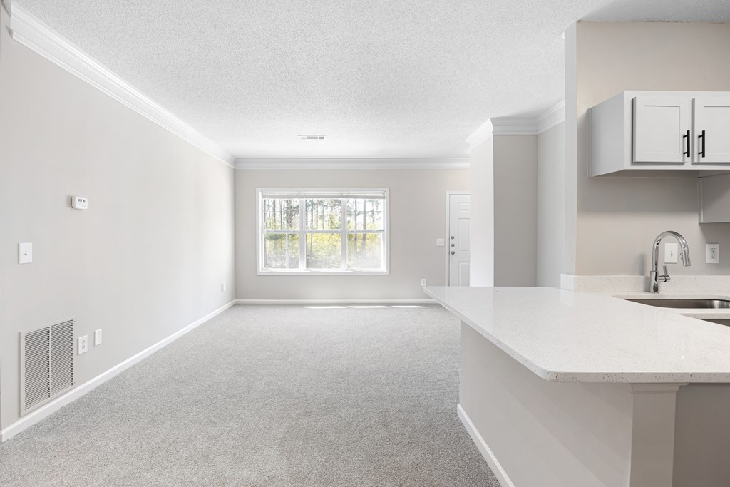 an empty kitchen and living room with a large window