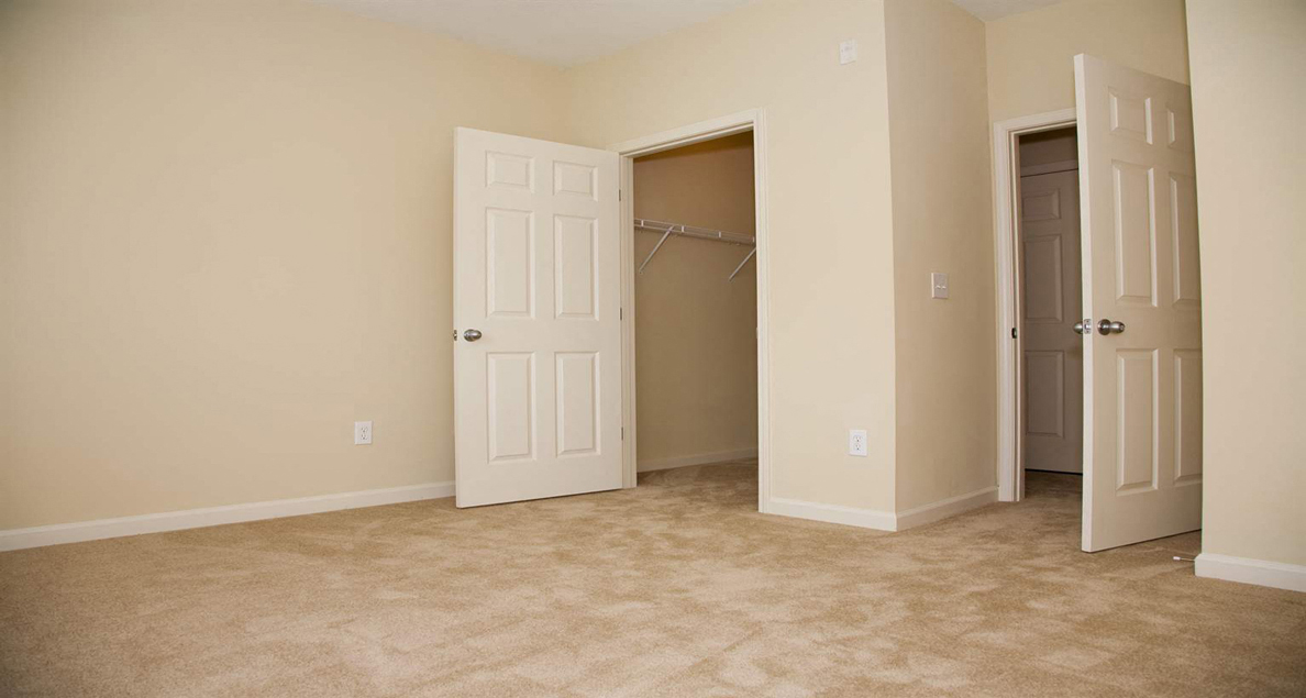 Bright guest bedroom with walk-in closet at The Columns at Oakwood, Oakwood, Georgia