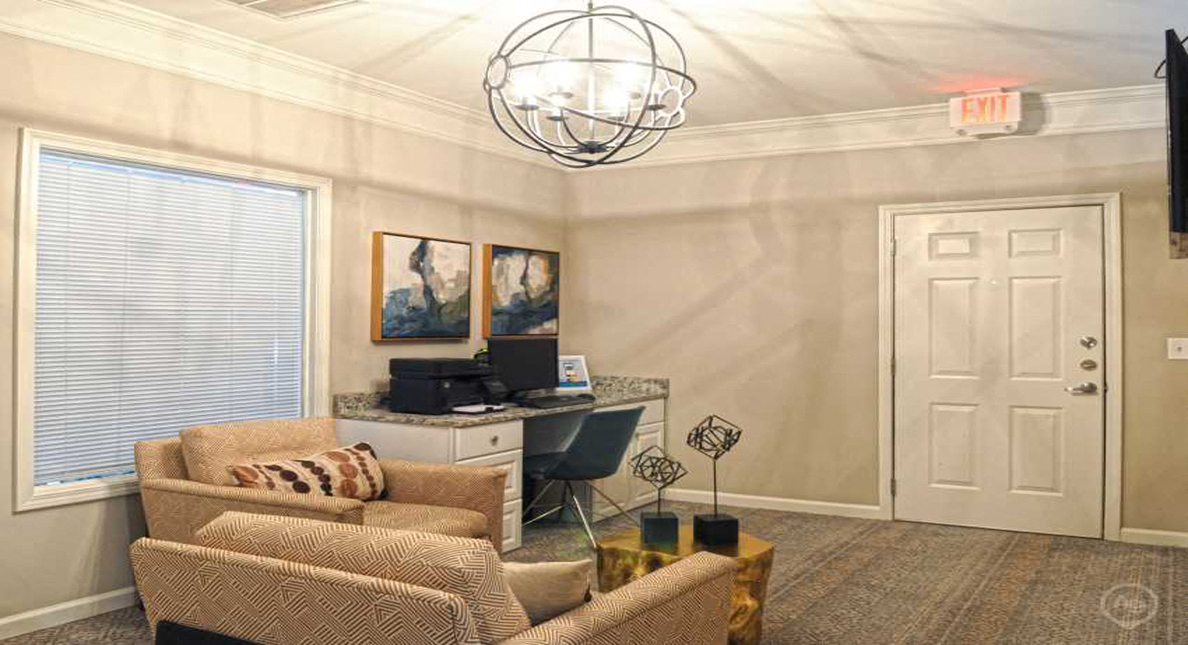 a living room with a couch and a desk with a computer