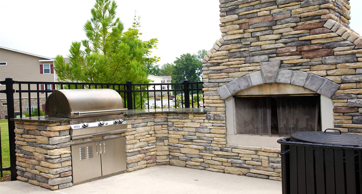 Up-close view of pool side grill and fireplace at The Columns at Oakwood, 30566