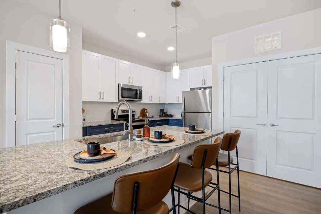 an open kitchen with granite counter tops and white cabinets