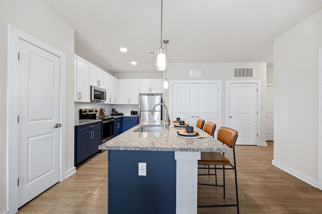 a kitchen with blue and white cabinets and a marble counter top