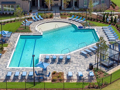 an aerial view of a swimming pool with lounge chairs