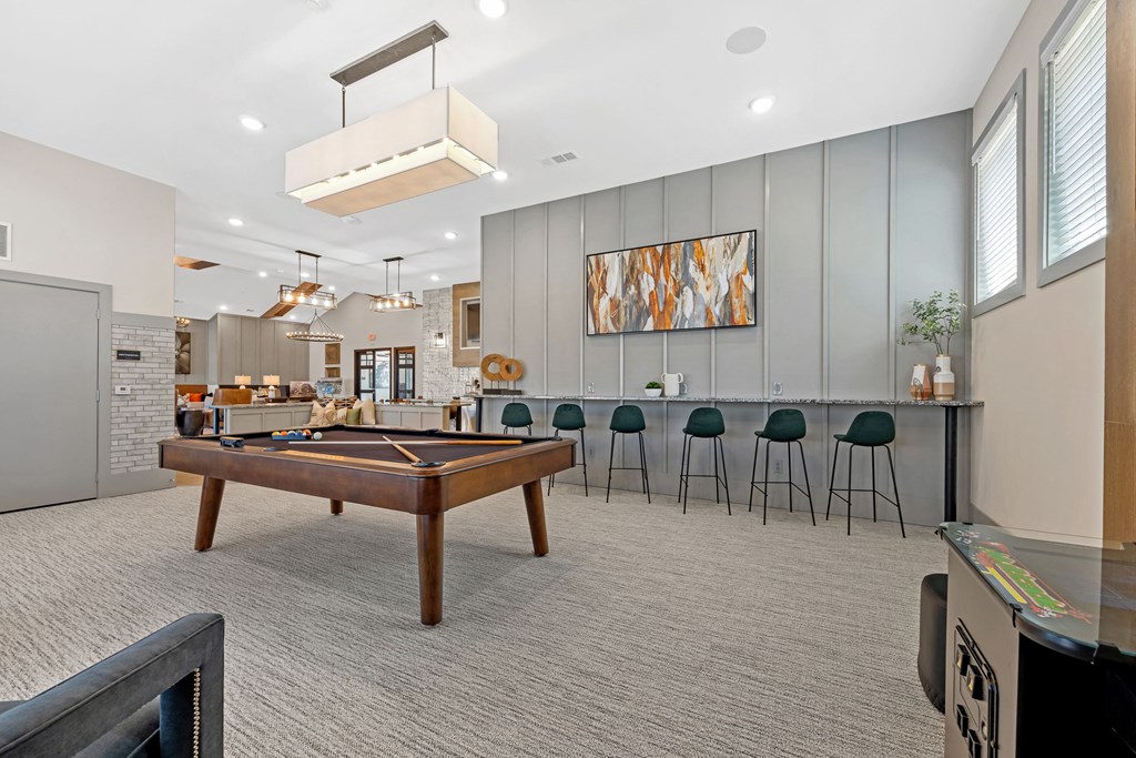 a game room with a pool table and a bar