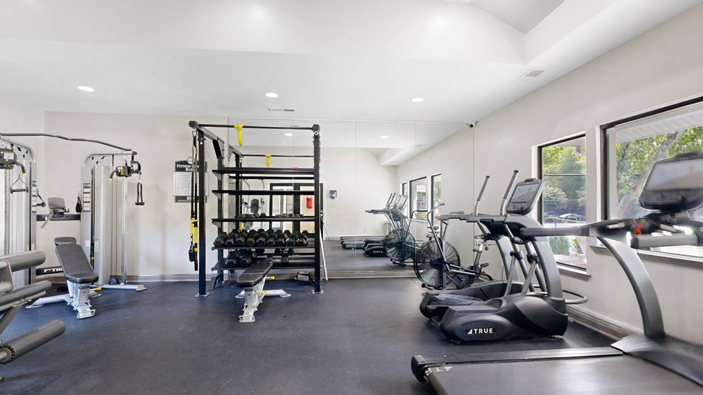 a room filled with lots of cardio equipment and weights