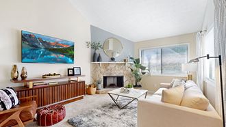 a living room with a fireplace and a large window - Photo Gallery 2