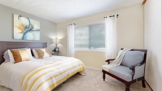 a bedroom with a bed and a chair - Photo Gallery 4