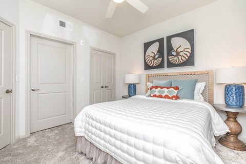 A bedroom with a large bed and a ceiling fan.