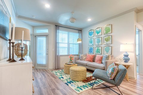 A living room with a grey sofa and a wicker ottoman.
