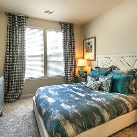 a bedroom with a bed and two windows