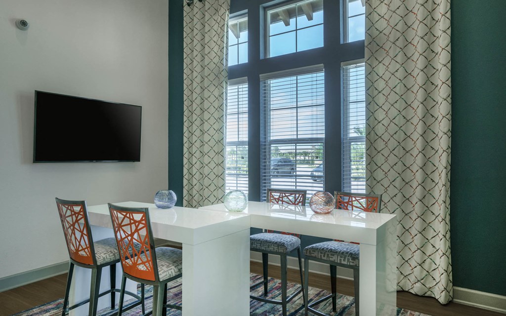 a seating area with a table and chairs in front of a window