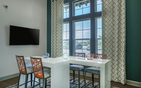 a seating area with a table and chairs in front of a window